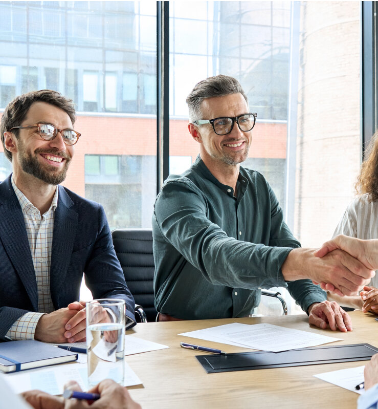 two people in a conference room shaking hands